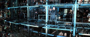 Movie still from “Harry Potter and the Goblet of Fire” (2005), directed by Mike Newell – A man in a suit standing in a building; Wide shot, High angle