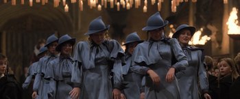 Movie still from “Harry Potter and the Goblet of Fire” (2005), directed by Mike Newell – A group of women in grey dresses and blue hats; Medium shot, Low angle