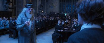 Movie still from “Harry Potter and the Goblet of Fire” (2005), directed by Mike Newell – A group of people sitting at a table in front of a crowd; Wide shot, High angle