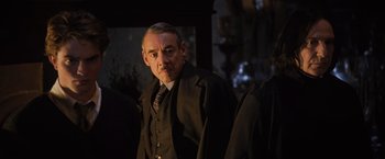 Movie still from “Harry Potter and the Goblet of Fire” (2005), directed by Mike Newell – A man in a suit and tie standing in front of a mirror; Medium shot, Over the shoulder angle