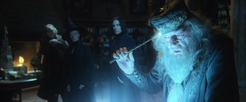 Movie still from “Harry Potter and the Goblet of Fire” (2005), directed by Mike Newell – A man holding a wand in front of two other people; Medium shot, Over the shoulder angle
