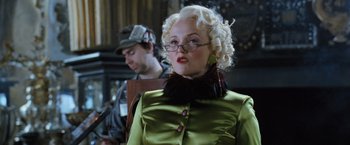 Movie still from “Harry Potter and the Goblet of Fire” (2005), directed by Mike Newell – An older woman with blonde hair wearing a green dress; Close Up shot, Low angle