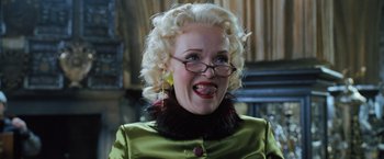 Movie still from “Harry Potter and the Goblet of Fire” (2005), directed by Mike Newell – An older woman with blonde hair wearing glasses and a green jacket; Close Up shot, Low angle