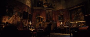 Movie still from “Harry Potter and the Goblet of Fire” (2005), directed by Mike Newell – A man sitting in a living room in front of a fireplace; Extreme Wide shot, Low angle