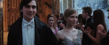 Movie still from “Harry Potter and the Goblet of Fire” (2005), directed by Mike Newell – A group of young people standing next to each other in formal wear; Medium shot, Low angle