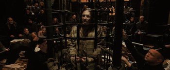 Movie still from “Harry Potter and the Goblet of Fire” (2005), directed by Mike Newell – A group of people standing around a cage; Medium shot, High angle