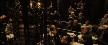 Movie still from “Harry Potter and the Goblet of Fire” (2005), directed by Mike Newell – A group of people sitting in a room; Wide shot, High angle