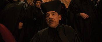Movie still from “Harry Potter and the Goblet of Fire” (2005), directed by Mike Newell – A man wearing a black robe and a black hat; Medium shot, Low angle