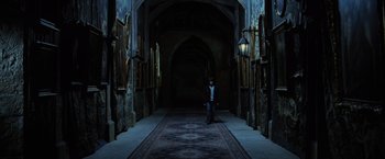 Movie still from “Harry Potter and the Goblet of Fire” (2005), directed by Mike Newell – A person standing in a dark hallway holding a cane; Wide shot, High angle