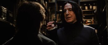Movie still from “Harry Potter and the Goblet of Fire” (2005), directed by Mike Newell – A man holding a bottle of potion in his hand; Close Up shot, Over the shoulder angle