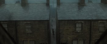 Movie still from “Harry Potter and the Half-Blood Prince” (2009), directed by David Yates – A person walking down a street in the rain; Extreme Wide shot, High angle