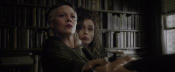 Movie still from “Harry Potter and the Half-Blood Prince” (2009), directed by David Yates – Two women sitting next to each other in front of a book shelf; Close Up shot, Low angle