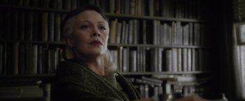 Movie still from “Harry Potter and the Half-Blood Prince” (2009), directed by David Yates – An older woman sitting in front of a book shelf; Close Up shot, Low angle