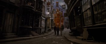 Movie still from “Harry Potter and the Half-Blood Prince” (2009), directed by David Yates – A group of people walking down a street near buildings; Wide shot, High angle