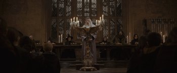 Movie still from “Harry Potter and the Half-Blood Prince” (2009), directed by David Yates – An old man with a long white beard is holding a candle; Wide shot, Low angle