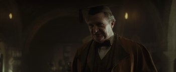 Movie still from “Harry Potter and the Half-Blood Prince” (2009), directed by David Yates – An older man wearing a hat in a dark room; Close Up shot, Over the shoulder angle