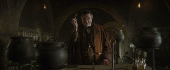 Movie still from “Harry Potter and the Half-Blood Prince” (2009), directed by David Yates – An old man holding a spoon in his hand; Medium shot, High angle
