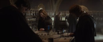 Movie still from “Harry Potter and the Half-Blood Prince” (2009), directed by David Yates – A group of people sitting around a table; Medium shot, Over the shoulder angle