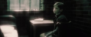 Movie still from “Harry Potter and the Half-Blood Prince” (2009), directed by David Yates – A boy sitting in a chair in front of a table; Medium shot, High angle