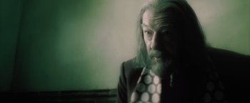 Movie still from “Harry Potter and the Half-Blood Prince” (2009), directed by David Yates – A man with long hair and a beard wearing a suit and tie; Close Up shot, Over the shoulder angle