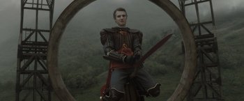 Movie still from “Harry Potter and the Half-Blood Prince” (2009), directed by David Yates – A man dressed as a medieval knight holding a sword; Medium shot, Low angle