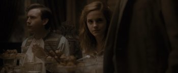 Movie still from “Harry Potter and the Half-Blood Prince” (2009), directed by David Yates – A woman sitting in front of a plate of food; Close Up shot, Over the shoulder angle