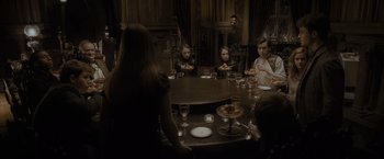 Movie still from “Harry Potter and the Half-Blood Prince” (2009), directed by David Yates – A group of people sitting around a table eating food; Wide shot, High angle
