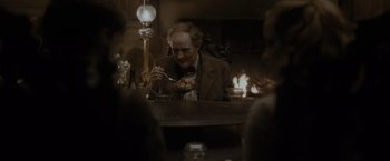 Movie still from “Harry Potter and the Half-Blood Prince” (2009), directed by David Yates – An older man eating a meal at a dinner table; Medium shot, Over the shoulder angle