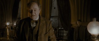 Movie still from “Harry Potter and the Half-Blood Prince” (2009), directed by David Yates – An older man in a suit and tie; Medium shot, Over the shoulder angle