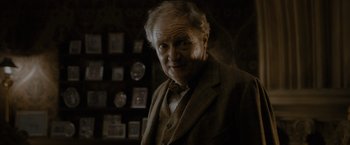 Movie still from “Harry Potter and the Half-Blood Prince” (2009), directed by David Yates – An older man in a suit and bow tie in a room; Close Up shot, Over the shoulder angle