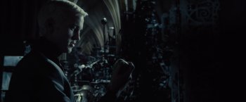 Movie still from “Harry Potter and the Half-Blood Prince” (2009), directed by David Yates – A man holding something in his hand while standing in a dark room; Close Up shot, Over the shoulder angle