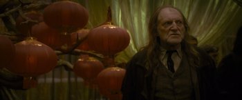 Movie still from “Harry Potter and the Half-Blood Prince” (2009), directed by David Yates – An old man standing next to a bunch of red lanterns; Medium shot, Over the shoulder angle