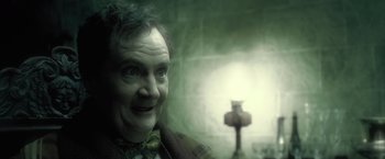 Movie still from “Harry Potter and the Half-Blood Prince” (2009), directed by David Yates – An old man with a bow tie is smiling for the camera; Close Up shot, Low angle