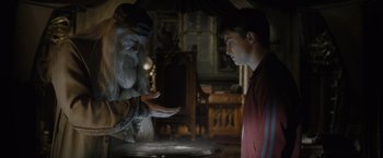 Movie still from “Harry Potter and the Half-Blood Prince” (2009), directed by David Yates – An old man and a young man are looking at something in a bowl; Medium shot, High angle