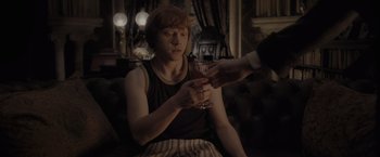 Movie still from “Harry Potter and the Half-Blood Prince” (2009), directed by David Yates – A man holding a wine glass in his hand; Medium shot, High angle