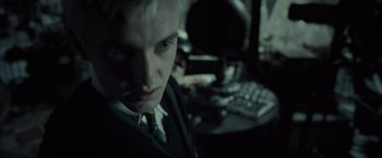 Movie still from “Harry Potter and the Half-Blood Prince” (2009), directed by David Yates – A young man in a suit and tie in front of a computer keyboard; Close Up shot, High angle