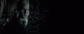 Movie still from “Harry Potter and the Half-Blood Prince” (2009), directed by David Yates – A man in a suit and tie looking at the camera; Close Up shot, Over the shoulder angle