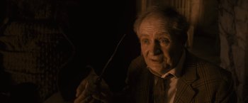 Movie still from “Harry Potter and the Half-Blood Prince” (2009), directed by David Yates – An older man holding a pair of scissors; Close Up shot, Over the shoulder angle