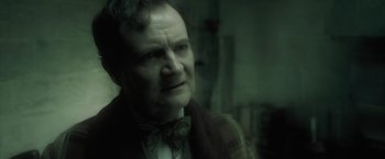 Movie still from “Harry Potter and the Half-Blood Prince” (2009), directed by David Yates – An older man wearing a bow tie looking at the camera; Close Up shot, Over the shoulder angle