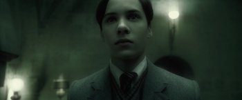 Movie still from “Harry Potter and the Half-Blood Prince” (2009), directed by David Yates – A man in a suit and tie looking up; Close Up shot, Low angle