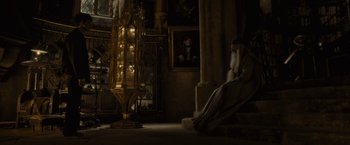 Movie still from “Harry Potter and the Half-Blood Prince” (2009), directed by David Yates – An old man sitting on a chair next to an old clock; Wide shot, High angle