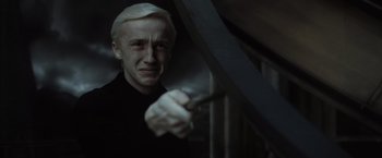 Movie still from “Harry Potter and the Half-Blood Prince” (2009), directed by David Yates – A man with blonde hair holding a knife in a dark room; Close Up shot, Low angle