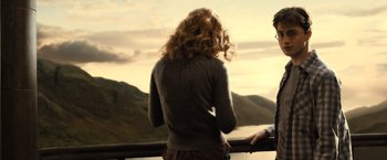 Movie still from “Harry Potter and the Half-Blood Prince” (2009), directed by David Yates – A woman standing next to a railing near a body of water; Medium shot, Over the shoulder angle
