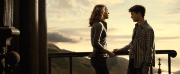 Movie still from “Harry Potter and the Half-Blood Prince” (2009), directed by David Yates – A woman standing next to a man on top of a building; Medium shot, Low angle