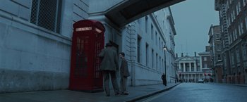 Movie still from “Harry Potter and the Order of the Phoenix” (2007), directed by David Yates – Two men are walking down the street in front of a red phone booth; Extreme Wide shot, Low angle