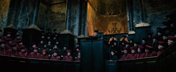 Movie still from “Harry Potter and the Order of the Phoenix” (2007), directed by David Yates – A group of people sitting in front of a podium; Wide shot, Low angle