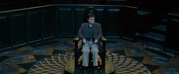 Movie still from “Harry Potter and the Order of the Phoenix” (2007), directed by David Yates – A man sitting in a chair in a court room; Wide shot, High angle