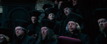 Movie still from “Harry Potter and the Order of the Phoenix” (2007), directed by David Yates – A group of people in black robes and hats; Medium shot, High angle