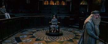 Movie still from “Harry Potter and the Order of the Phoenix” (2007), directed by David Yates – A person sitting on a chair in a room; Wide shot, High angle