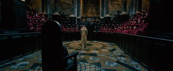 Movie still from “Harry Potter and the Order of the Phoenix” (2007), directed by David Yates – A man in a robe stands in front of an audience; Wide shot, High angle